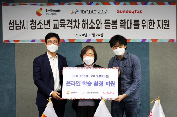 (사진 왼쪽부터) 양동기 스마일게이트 대외담당 사장, 진미석 성남시청소년재단 대표, 이현우 선데이토즈 애니팡4 PD가 지난 24일 성남시 중원구에 위치한 성남시청소년재단 중원청소년수련관에서 열린 저소득가정 청소년을 위한 스마트 기기 전달식에서 기념사진을 촬영하고 있다. (사진=스마일게이트)