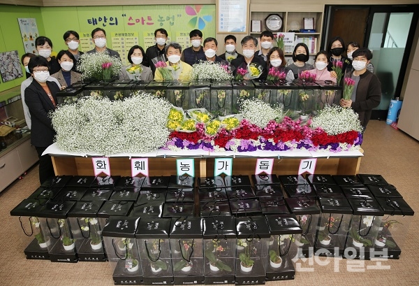 사진은 ‘플라워 오피스’를 만들기 위해 구입한 화분 앞에서 기념촬영을 하고 있는 군 농업기술센터 직원들 모습.(사진=태안군)