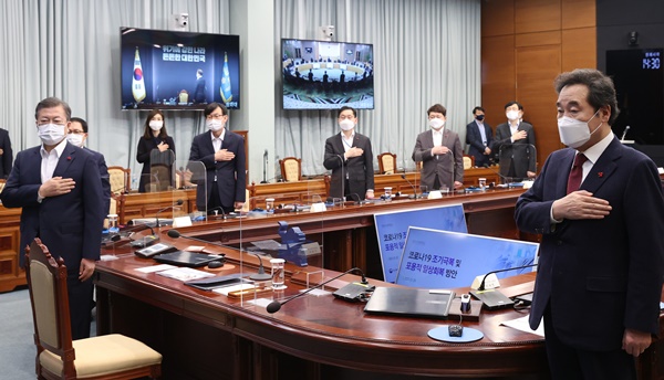 문재인 대통령이 25일 오후 청와대에서 열린 복지부·식약처·질병청 2021년 업무보고에 참석, 국기에 경례하고 있다. 오른쪽은 더불어민주당 이낙연 대표. (사진=연합뉴스)