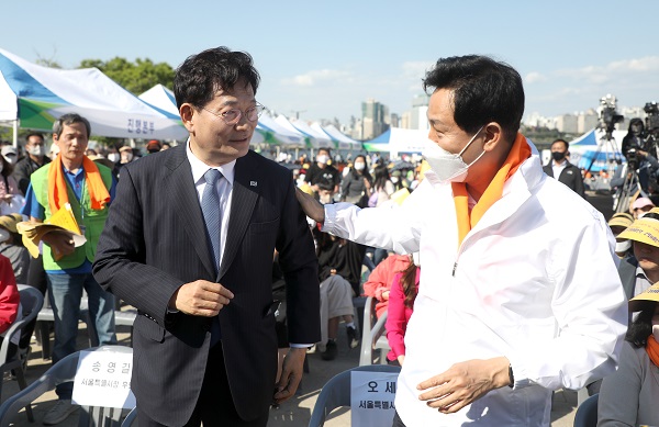 국민의힘 오세훈 서울시장 후보(오른쪽)와 더불어민주당 송영길 서울시장 후보가 지난 15일 서울 영등포구 여의도한강공원 이벤트 광장에서 열린 서울특별시학원연합회 2022 학교폭력예방 캠페인에 참석해 인사를 나누고 있다. (사진=연합뉴스)