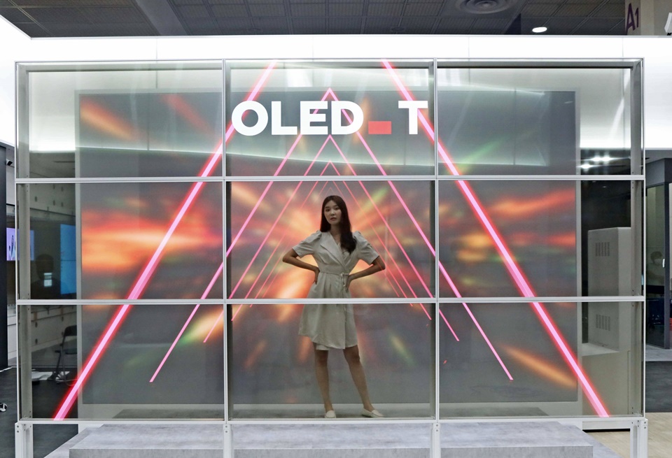 10일 서울 코엑스에서 열린 'K-디스플레이 2022'에서 55인치 투명 OLED 9대로 홀로그램을 구현한 LG디스플레이 ‘투명 포토월’을 체험하는 모습.[사진=LG디스플레이]